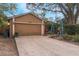 Tan house with attached garage and landscaping at 1309 Paradise Ln, Winter Park, FL 32792