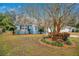 Cute light blue house with lush landscaping and a large tree in front at 1734 Weltin St, Orlando, FL 32803