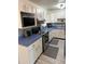 Galley kitchen featuring white cabinets, blue countertops, and stainless steel appliances at 1801 Hage Way, Orlando, FL 32805