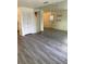 Living room with gray vinyl plank flooring, mirror wall, and entryway at 1801 Hage Way, Orlando, FL 32805