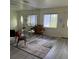 Bright living room with large window, entry door, and decorative rug and chairs at 1801 Hage Way, Orlando, FL 32805