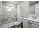 Modern bathroom with marble-look shower, white vanity, and toilet at 1913 Nw 12Th St, Ocala, FL 34475