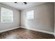 Bedroom with wood-look floors, ceiling fan, and two windows at 1913 Nw 12Th St, Ocala, FL 34475