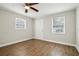 Bright bedroom with wood-look floors, ceiling fan, and two windows at 1913 Nw 12Th St, Ocala, FL 34475