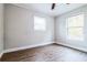 Bedroom with wood-look floors, ceiling fan, and two windows at 1913 Nw 12Th St, Ocala, FL 34475