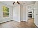 Bedroom with wood-look floors, ceiling fan, and kitchen view at 1913 Nw 12Th St, Ocala, FL 34475