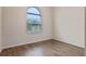 Cozy bedroom with wood-look floors and an arched window at 1943 Sipes Ave, Sanford, FL 32771