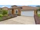 Front view of house with driveway, landscaping, and white garage door at 1943 Sipes Ave, Sanford, FL 32771