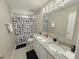 Main bathroom with double sinks and patterned shower curtain at 261 Primrose Dr, Davenport, FL 33837