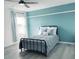 Bedroom with light grey wood flooring, blue walls, and a metal bed frame at 4139 Calusa Pine Rd, Daytona Beach, FL 32124