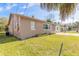 Side view of tan house, showcasing a well-maintained lawn at 421 Jefferson St, Daytona Beach, FL 32114