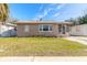 Tan single story home with landscaped lawn, walkway and screened porch at 421 Jefferson St, Daytona Beach, FL 32114