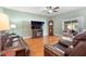 Living room with hardwood floors, brown leather couches, and fireplace at 4847 Havilland Dr, Mount Dora, FL 32757