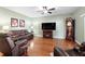 Living room with hardwood floors, brown leather couches, and fireplace at 4847 Havilland Dr, Mount Dora, FL 32757
