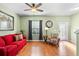 Living room with hardwood floors, red couch, and access to backyard at 4847 Havilland Dr, Mount Dora, FL 32757