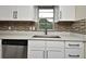 White cabinets, quartz countertop, and stylish backsplash in renovated kitchen at 5803 Clearview Dr, Orlando, FL 32819