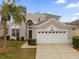 Two-story house with beige exterior and white garage at 8106 Fan Palm Way, Kissimmee, FL 34747
