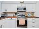 Modern kitchen with white cabinets, butcher block countertops and stainless steel appliances at 844 Sugar House Dr, Port Orange, FL 32129
