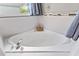 Relax in this corner soaking tub, featuring modern tile and fixtures at 935 Don Wilson Ave, Apopka, FL 32712