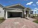 One-story home with two-car garage and brick driveway at 1141 Lakeshore Breeze Pl, Kissimmee, FL 34747