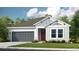 Craftsman style home with gray garage door and red front door at 1218 Teal Creek Dr, St Cloud, FL 34771