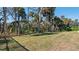 Landscaped backyard with lush lawn and mature trees at 1406 Saxon Dr, New Smyrna Beach, FL 32169