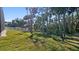 Private backyard with a grassy area and mature trees at 1406 Saxon Dr, New Smyrna Beach, FL 32169