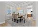 Bright dining room with a view into the kitchen, features a wooden table with beige chairs and a stylish light fixture at 1406 Saxon Dr, New Smyrna Beach, FL 32169