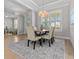 Dining room featuring a wooden table, neutral-toned chairs, and a large area rug at 1406 Saxon Dr, New Smyrna Beach, FL 32169