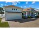 White house with a brown roof and a large garage at 1406 Saxon Dr, New Smyrna Beach, FL 32169