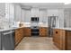 Modern kitchen featuring stainless steel appliances, light wood cabinetry, and quartz countertops at 1406 Saxon Dr, New Smyrna Beach, FL 32169