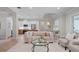 Living room with a beige sofa, glass coffee table, and an open kitchen view at 1406 Saxon Dr, New Smyrna Beach, FL 32169