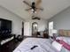 Spacious main bedroom with a large TV, a walk-in closet and carpet flooring at 15824 Marsh Elder St, Clermont, FL 34711