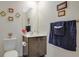 Clean bathroom with dark brown vanity and navy striped towels at 1643 Wynford Cir, Tavares, FL 32778