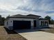 Modern two-car garage home with gray and white exterior and landscaping at 16674 Sw 25Th Ct, Ocala, FL 34473