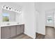 Bathroom featuring double vanity sinks, ample lighting, and a large mirror at 1864 Maple Plum Ct, Sanford, FL 32771