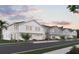 Row of townhomes with gray and white siding and two-car garages at 205 Glass Onion Dr, Howey In The Hills, FL 34737