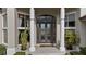 Elegant entryway with double doors, columns, and lush potted plants at 2224 Alaqua Dr, Longwood, FL 32779