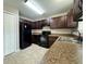 Modern kitchen with dark cabinets, black appliances, and granite countertops at 2650 Sw 162Nd Ln, Ocala, FL 34473