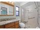 Bathroom with decorative mirror, granite countertop, toilet, and a glass-enclosed shower with a seat at 2717 Rose Moss Ln, Orlando, FL 32807