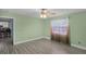 Bright bedroom features light green walls, tile flooring, ceiling fan, and a doorway into the kitchen at 2717 Rose Moss Ln, Orlando, FL 32807