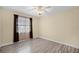 Bedroom featuring neutral walls, wood-look tile flooring, ceiling fan, and a window with patterned curtains at 2717 Rose Moss Ln, Orlando, FL 32807