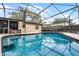 Backyard pool featuring an enclosed screen, patio, and a well-manicured landscape at 2717 Rose Moss Ln, Orlando, FL 32807