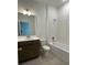 Bright bathroom featuring a modern vanity with a single sink and a shower-over-tub with white tiles at 27469 Black Kite Ave, Howey In The Hills, FL 34737