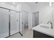 Sleek bathroom with glass-enclosed shower, dual vanity with modern fixtures, and white tile at 27469 Black Kite Ave, Howey In The Hills, FL 34737