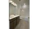Well-lit bathroom with double sink vanity, tiled floor and shower-over-tub perfect for a growing Gathering at 27469 Black Kite Ave, Howey In The Hills, FL 34737