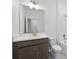 Well-lit bathroom showcasing a vanity with modern fixtures, a toilet, and a tiled shower at 27469 Black Kite Ave, Howey In The Hills, FL 34737