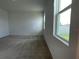 Inviting bedroom featuring large windows that provides an abundance of natural light and neutral carpet at 27469 Black Kite Ave, Howey In The Hills, FL 34737