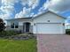 Beautiful single-story home featuring a paver driveway and landscaped front yard at 27469 Black Kite Ave, Howey In The Hills, FL 34737