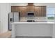 Modern kitchen featuring stainless steel appliances, white quartz countertops, and sleek brown cabinetry at 27469 Black Kite Ave, Howey In The Hills, FL 34737